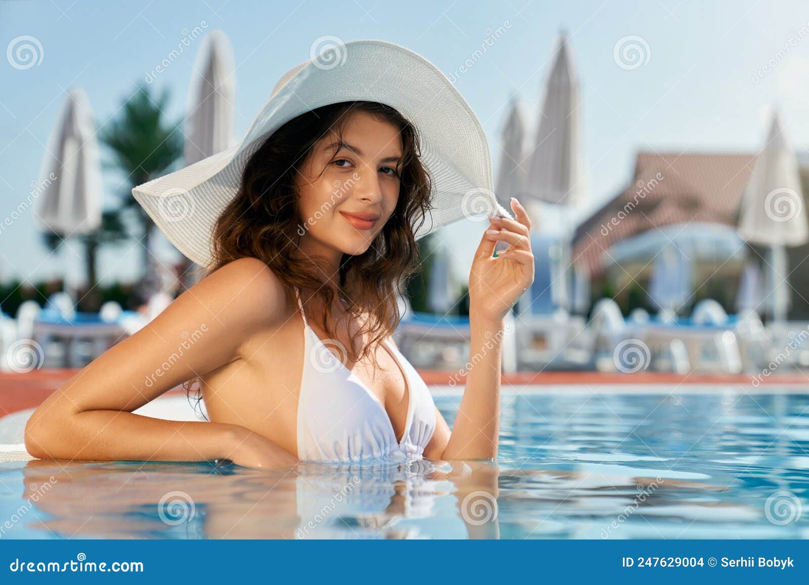 Mujer bonita con gorra de baño en la piscina