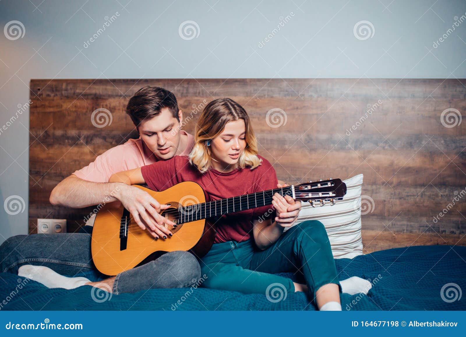 https://thumbs.dreamstime.com/z/bonita-pareja-descansando-en-casa-y-tocando-guitarra-joven-novio-ense%C3%B1ando-su-novia-tocar-la-encantadora-usando-ropa-informal-164677198.jpg