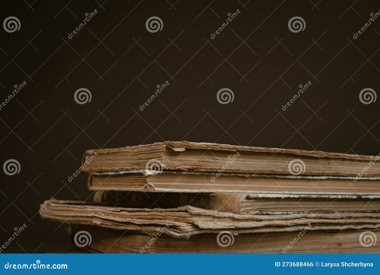 A Stack of Old Books with Frayed Spines and Yellowed Pages Stock Photo