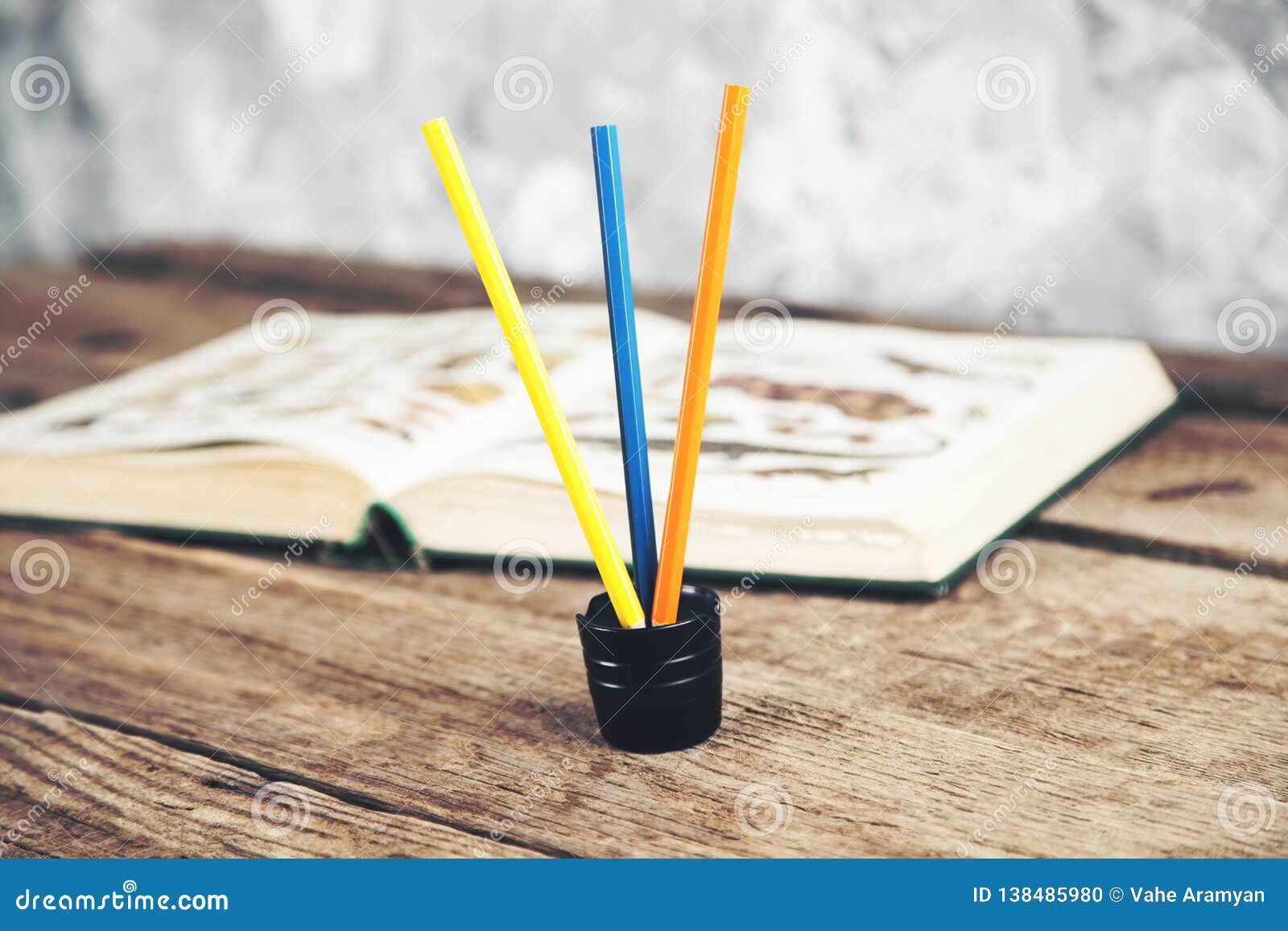 Book with pencils on desk stock photo. Image of back 138485980