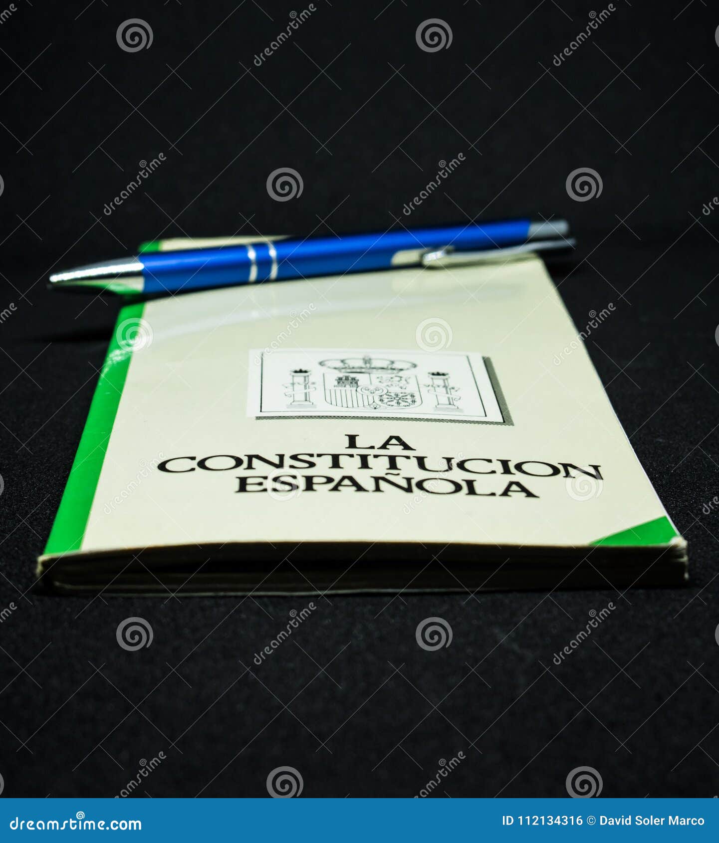 book of the spanish constitution wiht a pen and the graphical white background