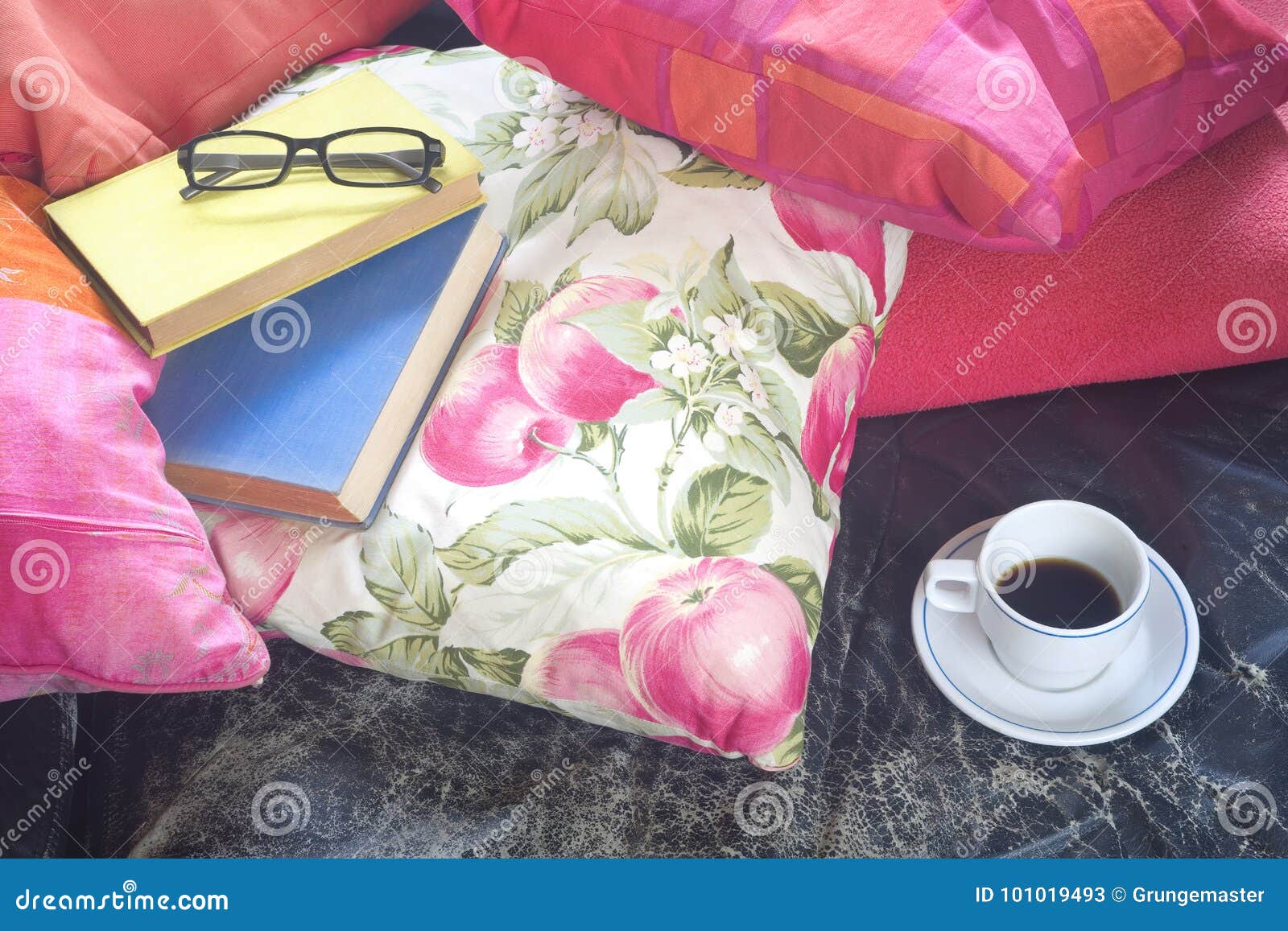 books on a sofa with cup of coffee and specs