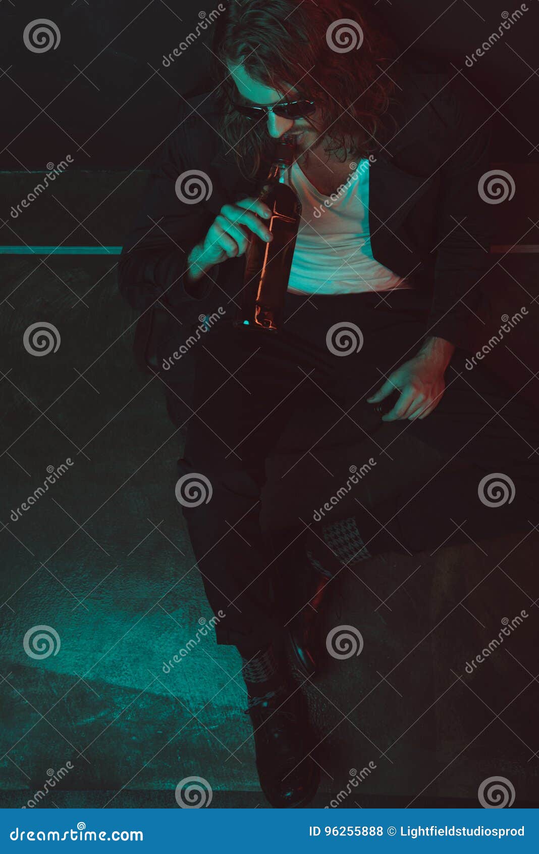 Boozer in Sunglasses Drinking Alcohol from Bottle while Sitting on the