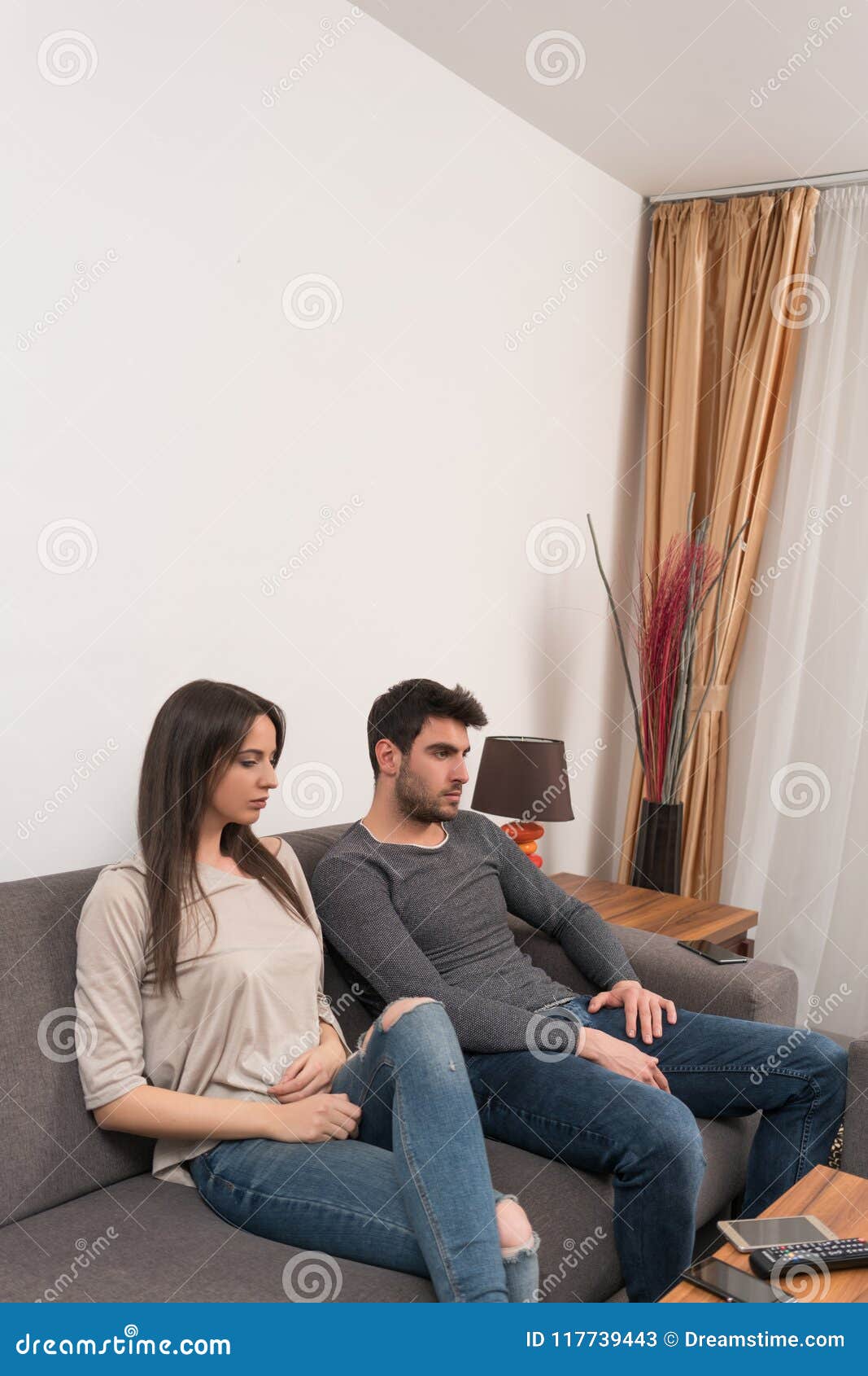 bored young couple sitting on couch.