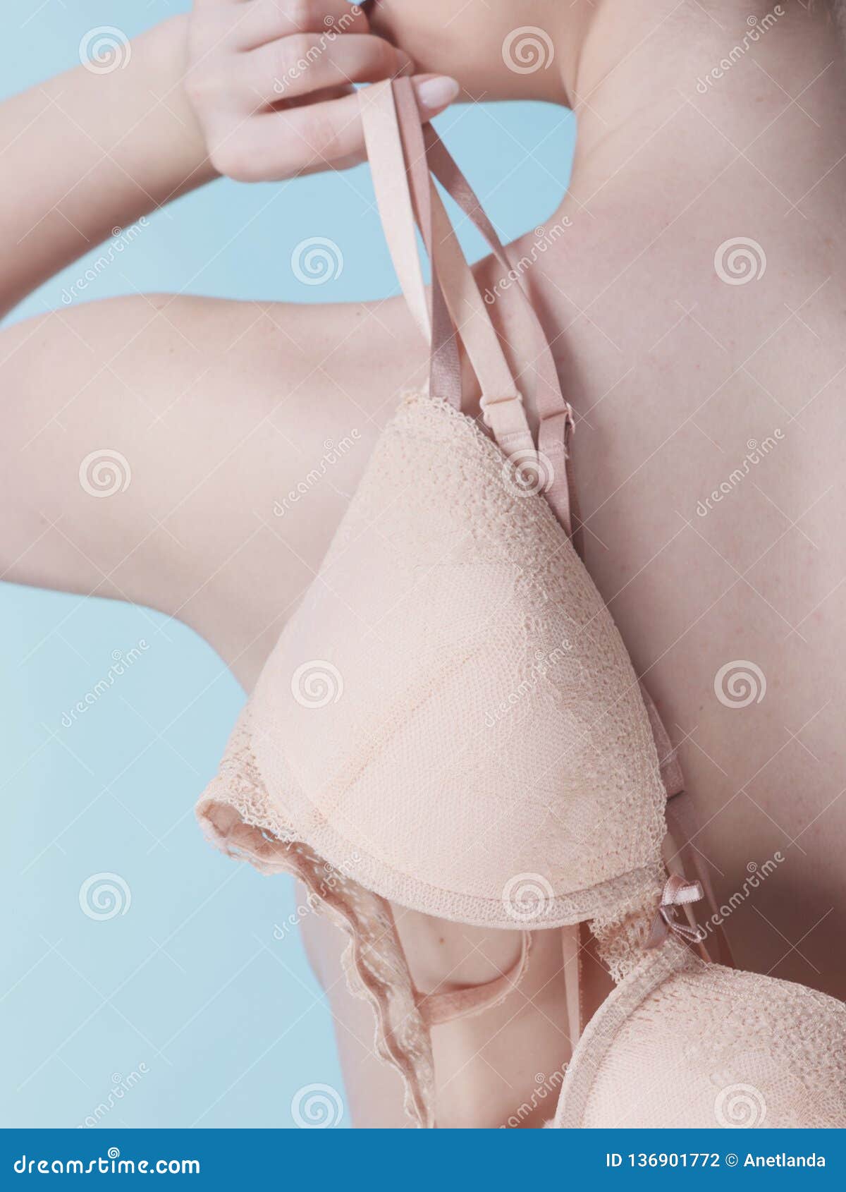 Nude woman holding bra Stock Photo - Alamy