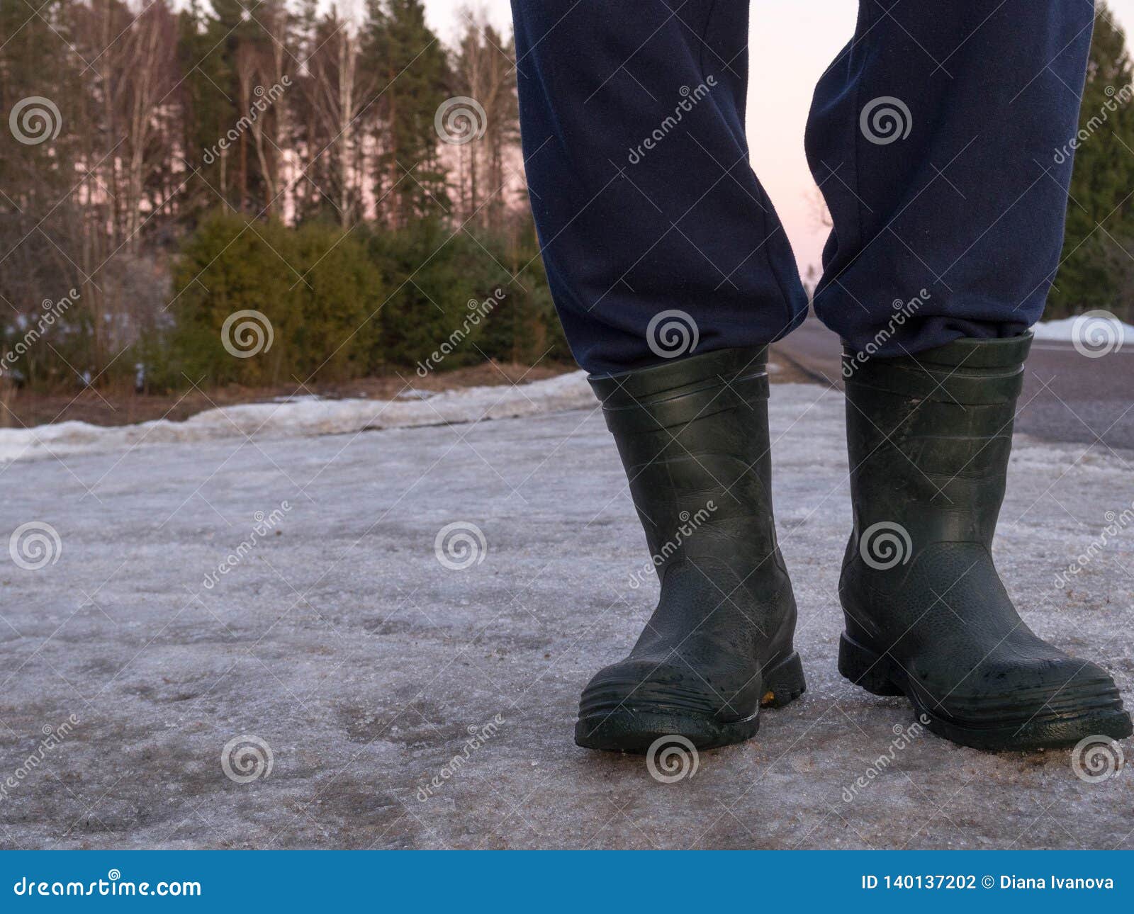 Botas De Goma Para El Uso Del Trabajo Un Trabajador De En El Asfalto Gris, Frío Foto de archivo - sunset, impermeable: 140137202