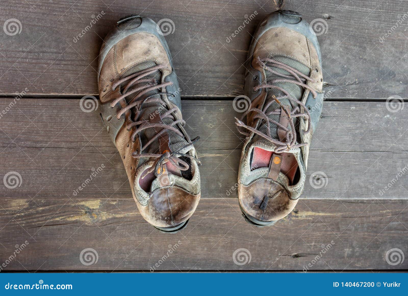 Botas Gastadas Viejas Que Se Colocan En Un Piso De Madera de archivo - Imagen de 140467200