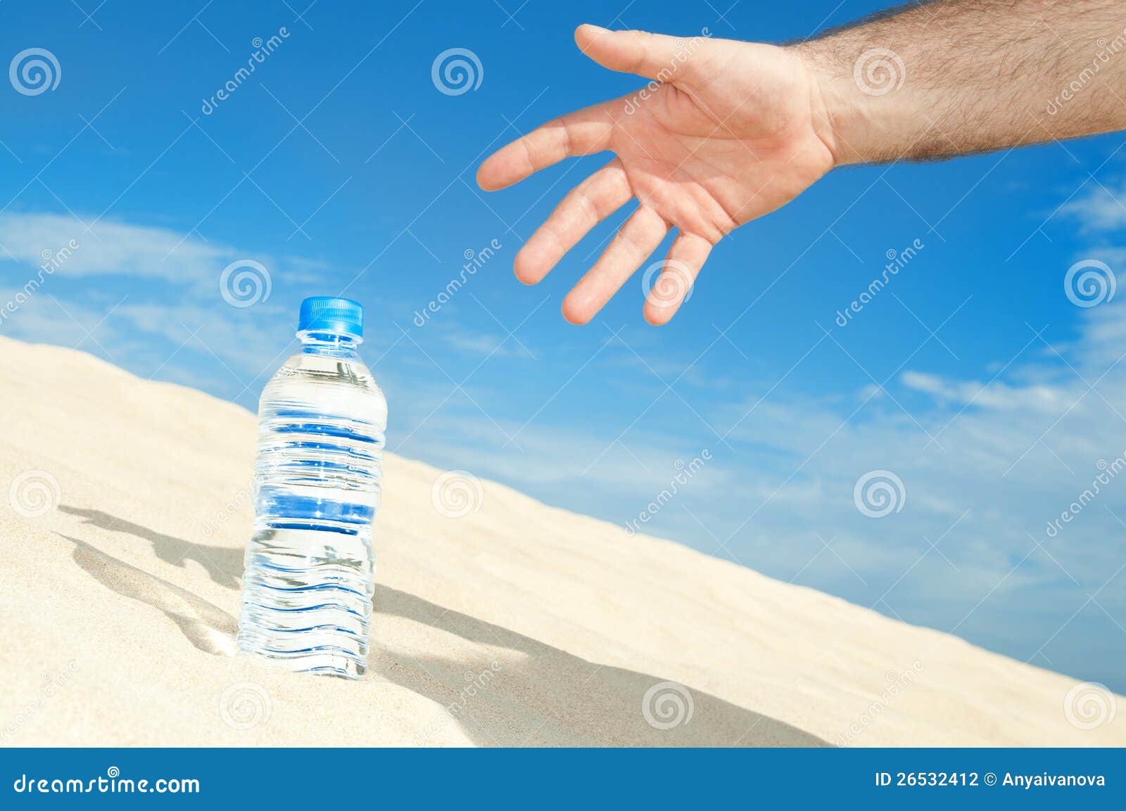 La mano del hombre alcanza para una botella de agua en el desierto