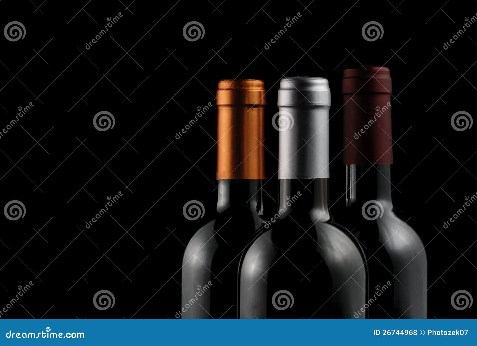Ciérrese para arriba de tres botellas de vino sobre fondo negro