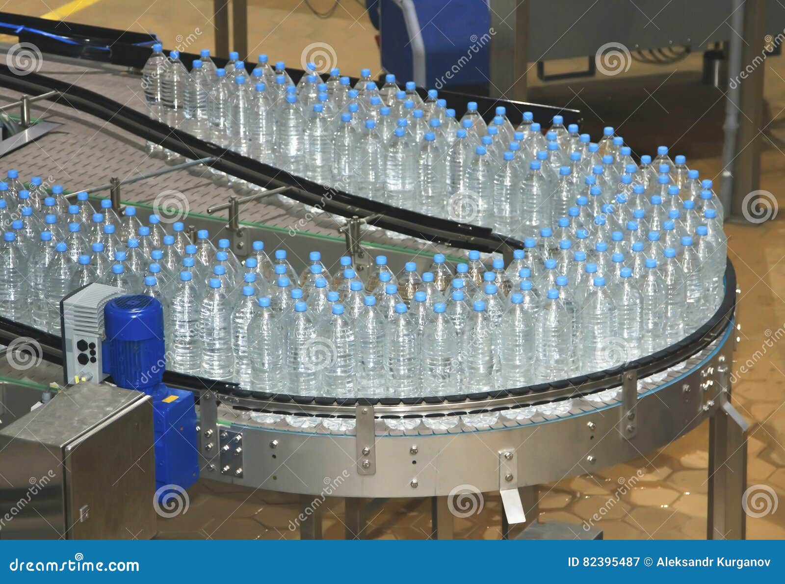 Bottiglie di acqua sull'imbottigliatrice ind dell'acqua e del trasportatore. Bottiglie di acqua di plastica su industria dell'imbottigliatrice dell'acqua e del trasportatore