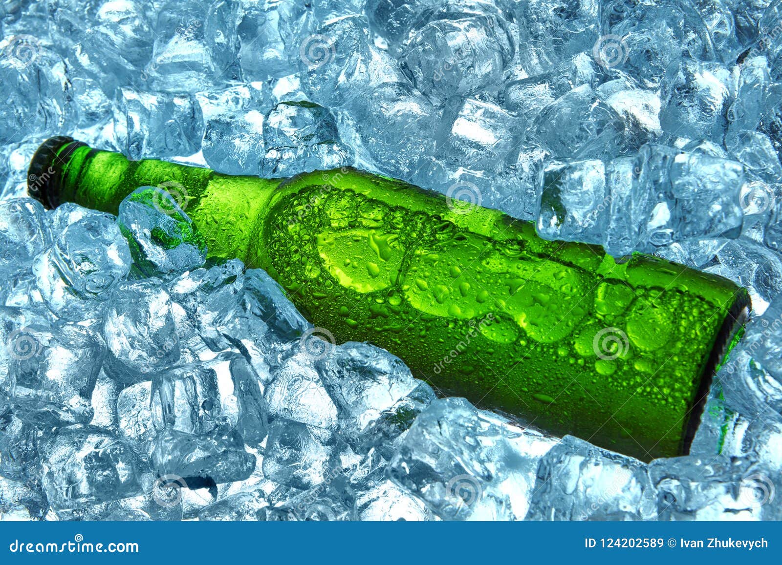 Bottle of beer in ice cubes.Closeup.Green bottle.Hot Summer fresh drinkÑŽ