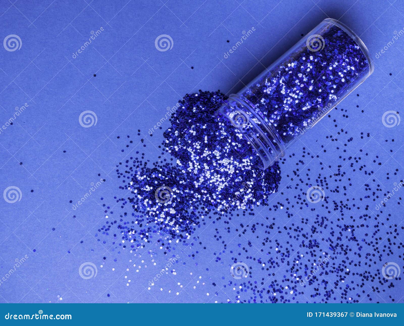 Bottle with Blue Color Glitter Inside on Blue Trendy Background. Trendy