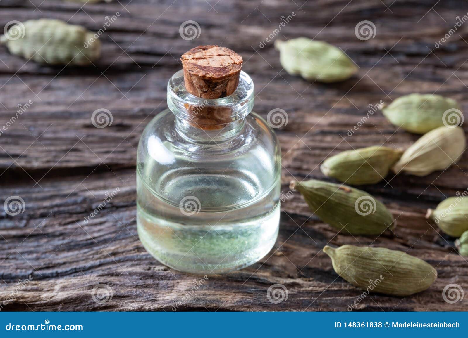 A Bottle of Cardamon Essential Oil with Cardamon Seeds Stock Photo