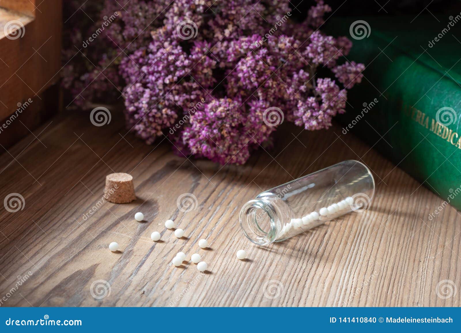 a bottle of homeopathic globules with dried herbs and materia medica