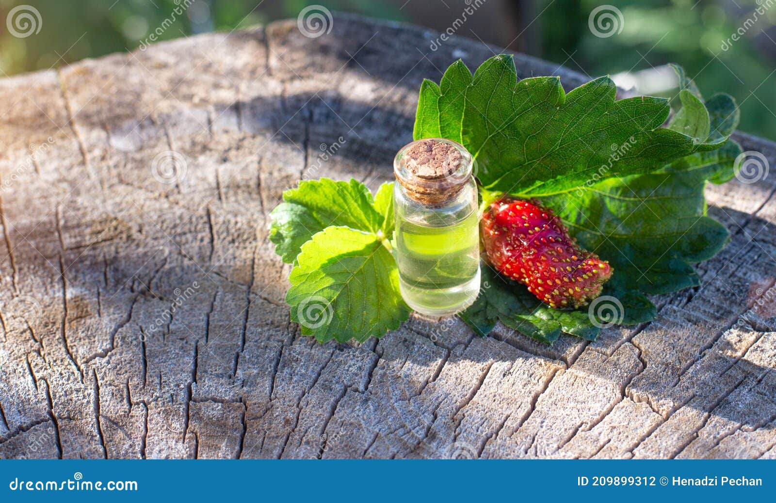 Bottle with Perfume from Strawberry Essential Oil on a Wooden