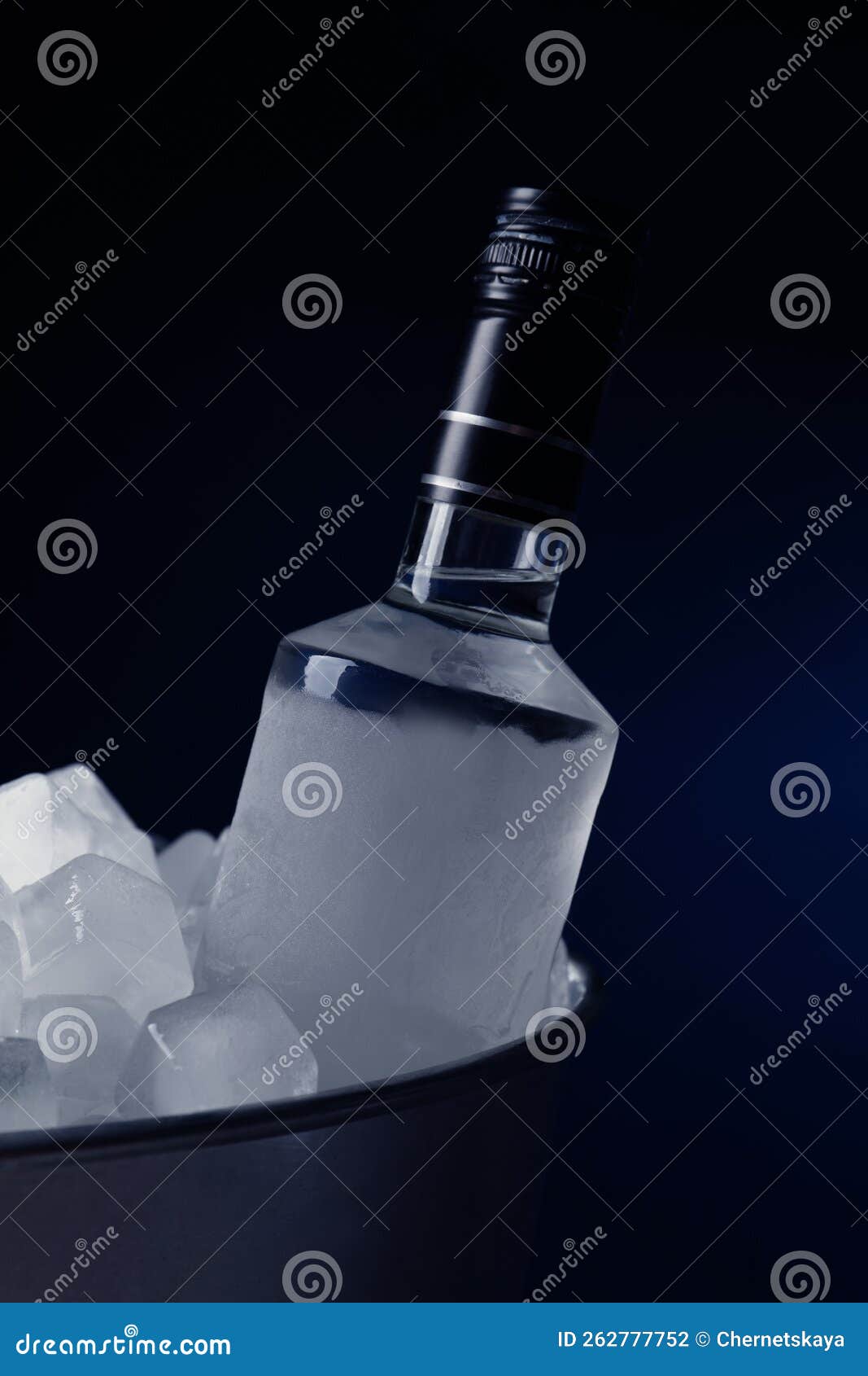 Bottle of Vodka in Metal Bucket with Ice on Dark Background Stock Photo