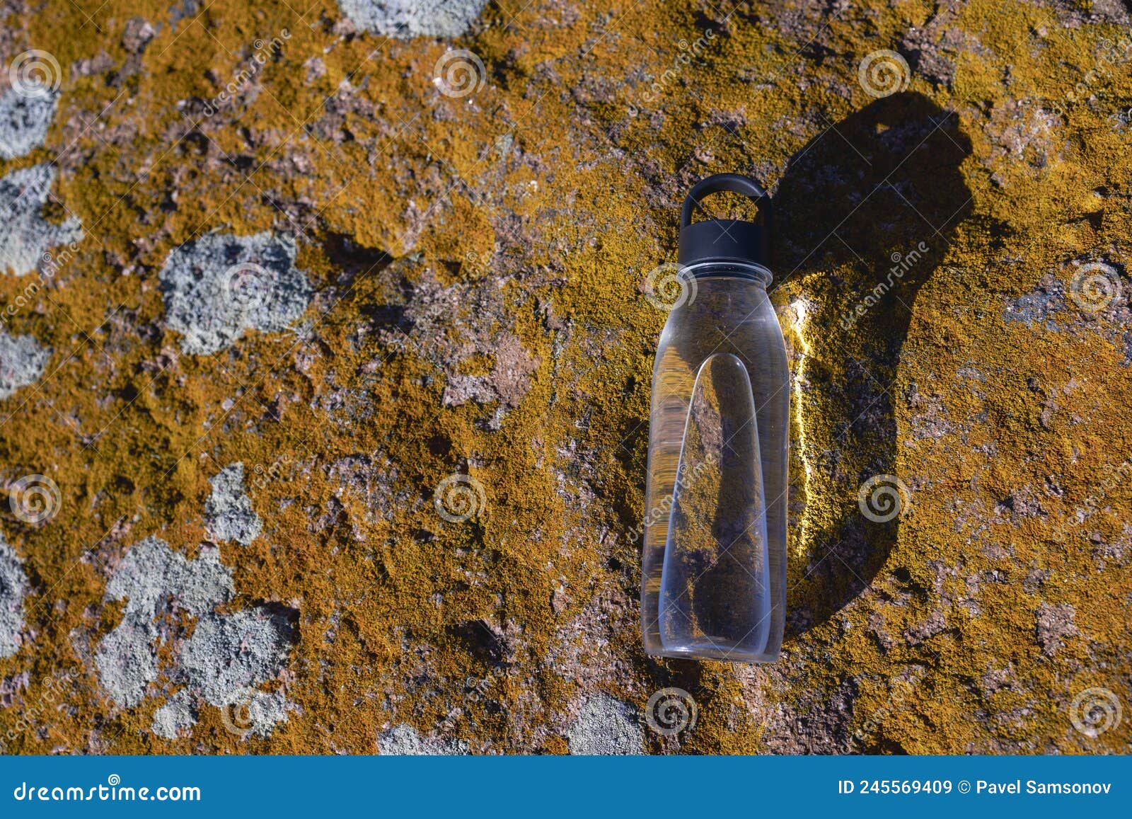 a bottle of water lies on a stone.