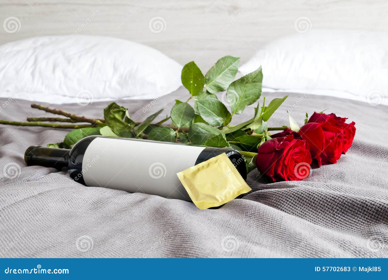 Bottle Of Wine Roses And Condom On Bed Set Stock Image