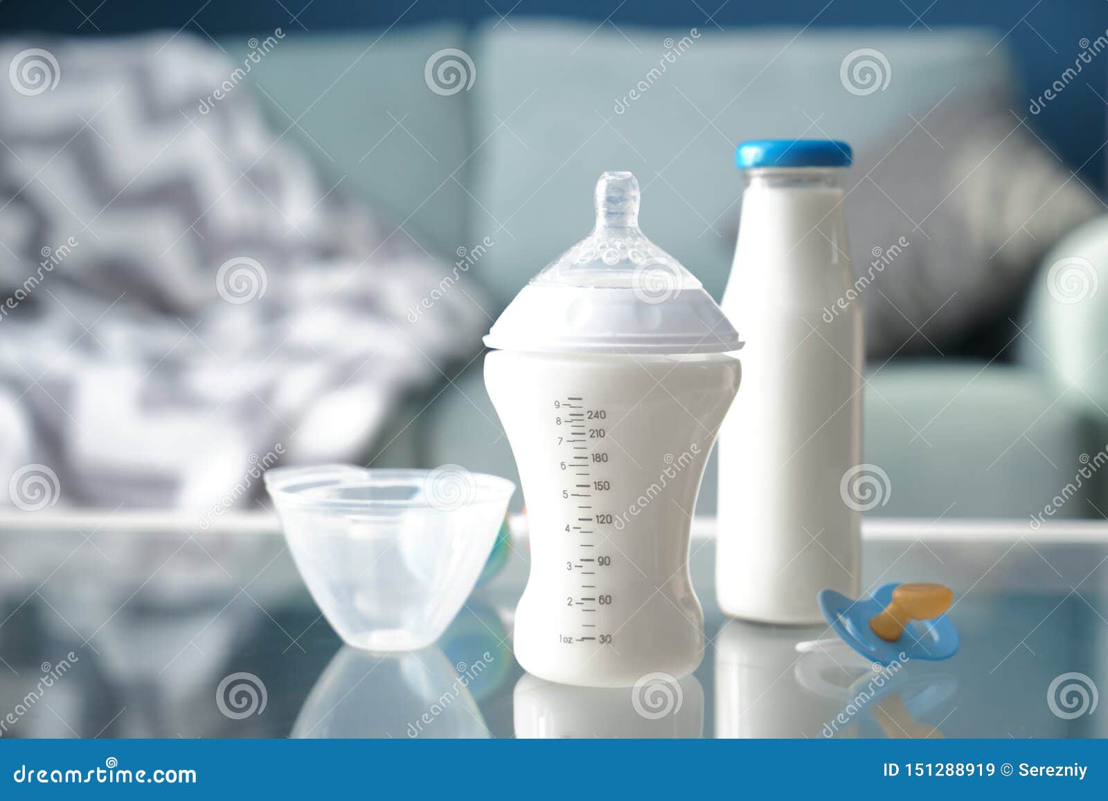 Bottles of Baby Formula with Pacifier on Glass Table Stock Image