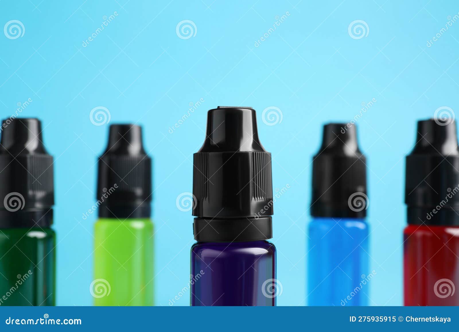 Bottles with Different Food Coloring on Light Blue Background, Closeup