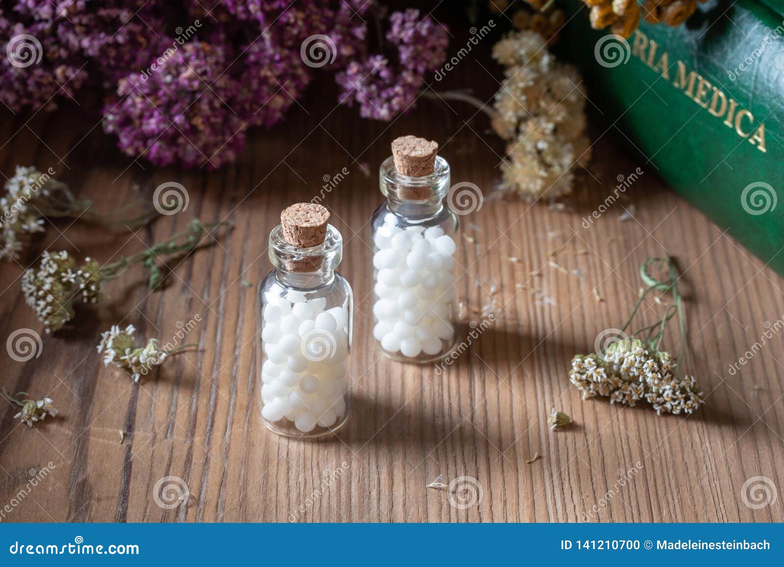 bottles of homeopathic pills with dried herbs and materia medica