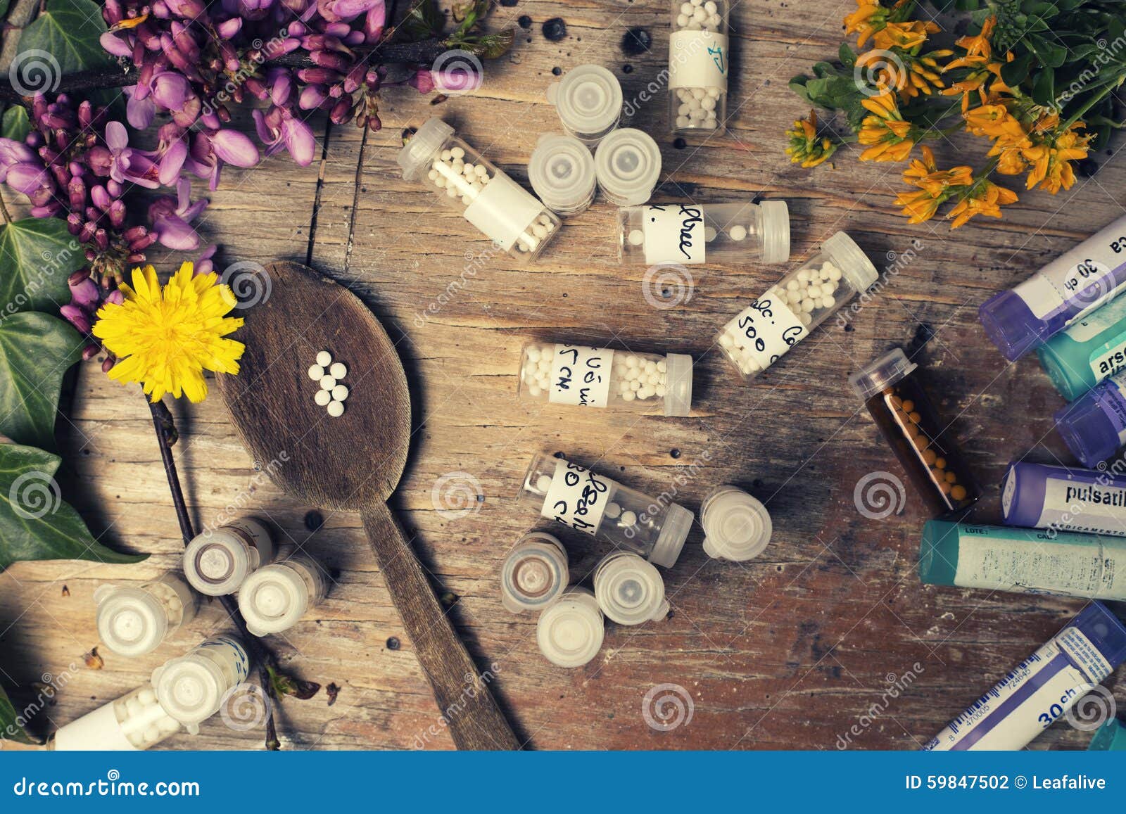 bottles with homeopathy globules and spoon, decorated with flowe