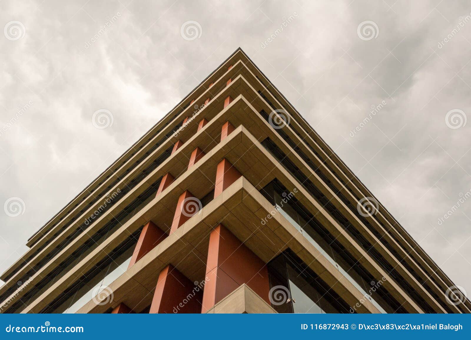bottom view of modern building in business district against overcast sky