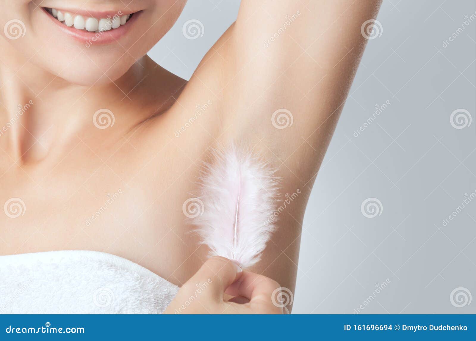 after the botulinum toxin injection procedure. a woman holds a feather in the skin in the armpits, showing dryness and lack of