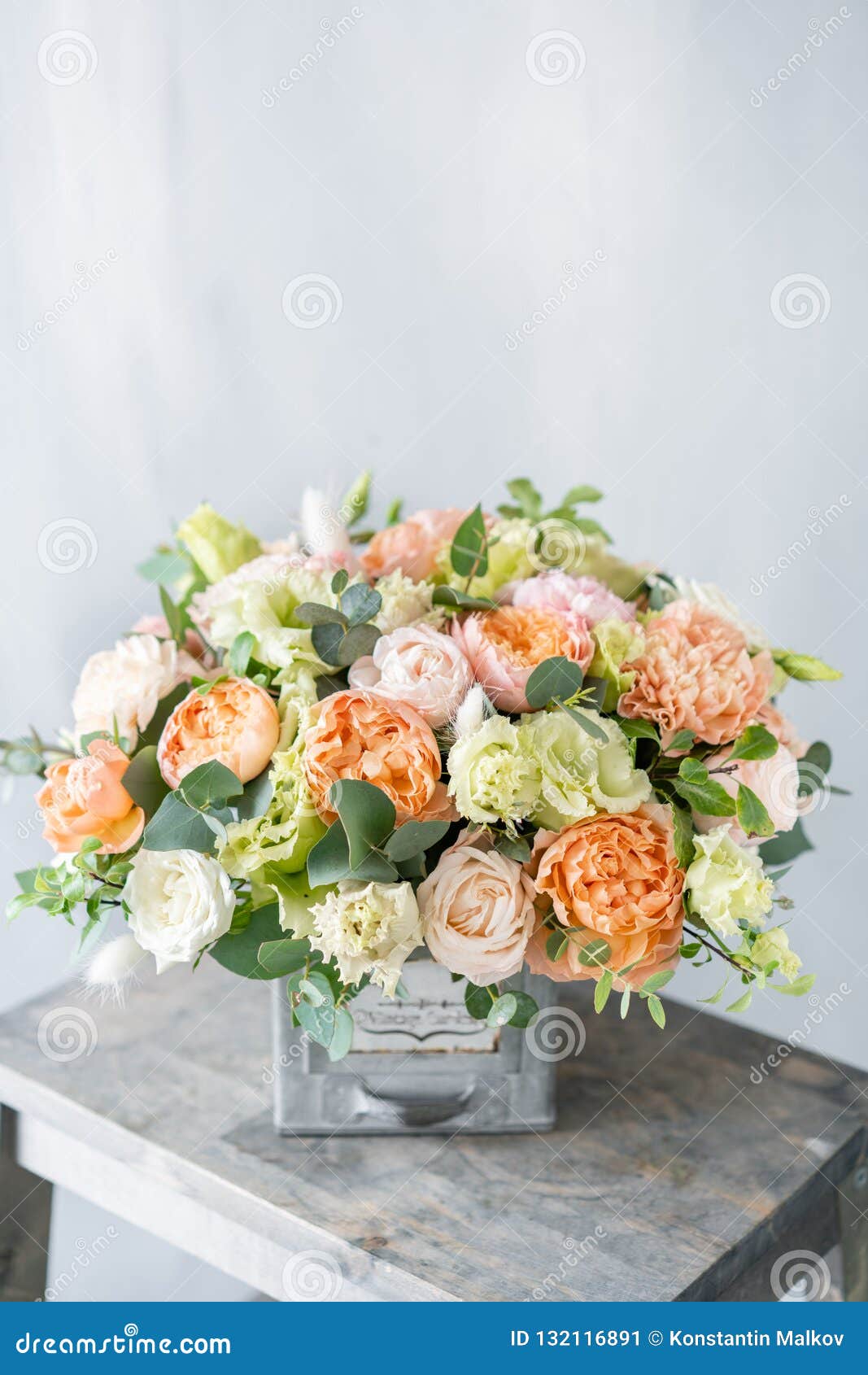 bouquet of fresh spring flowers on gray wall background. floral arrangement in vintage metal vase. flower shop, florist