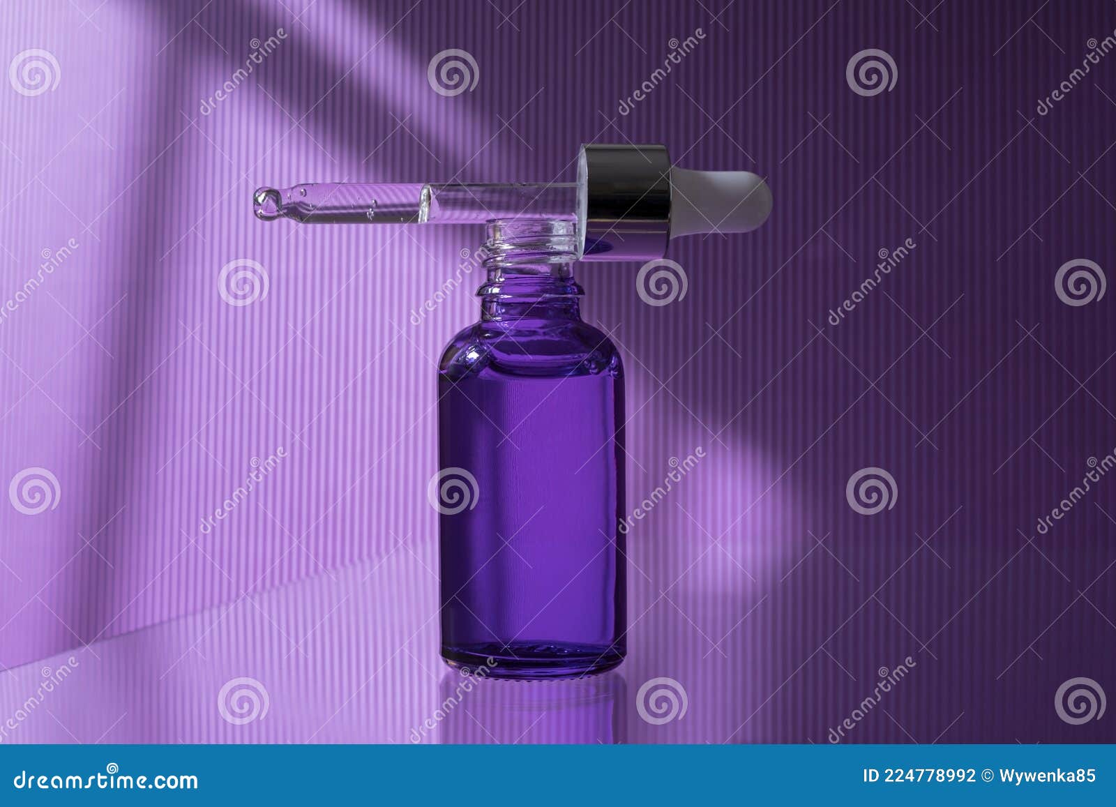 Flacon de pipette violet en verre plastique cosmétique. Fleurs de