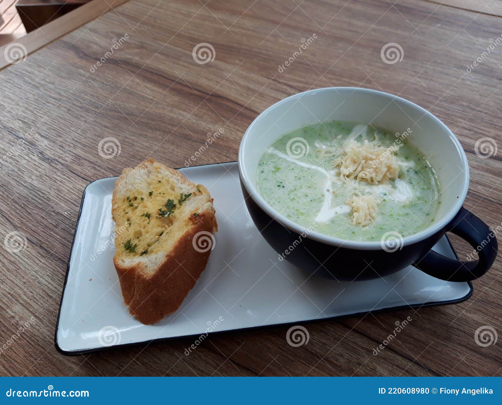 A Bowl of Brocolli Cheese Soup with Garlic Bread Stock Photo - Image of ...