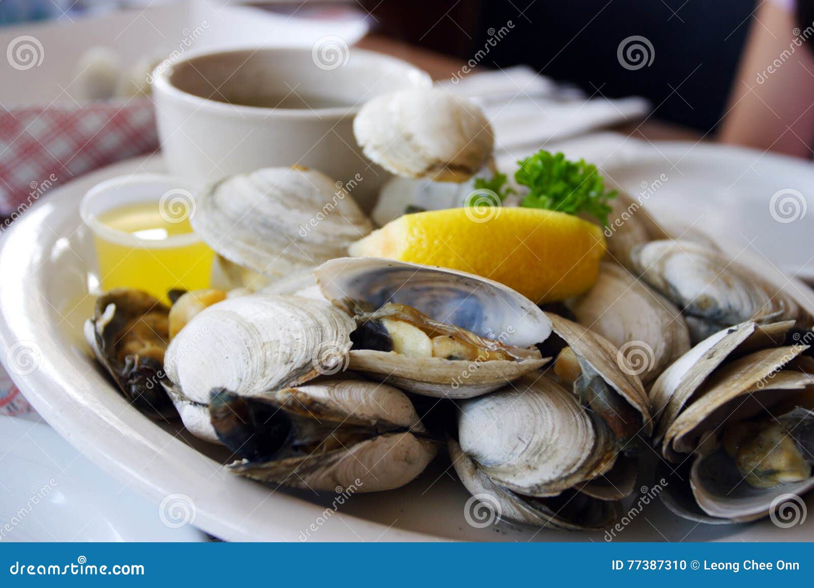bowl of delicious fresh steamer clams with lemon and broth