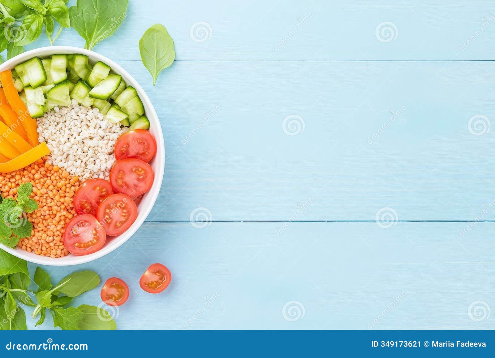 a bowl of fresh ingredients, including tomatoes, lentils, cucumbers, and carrots, with mint and spinach, on a pastel