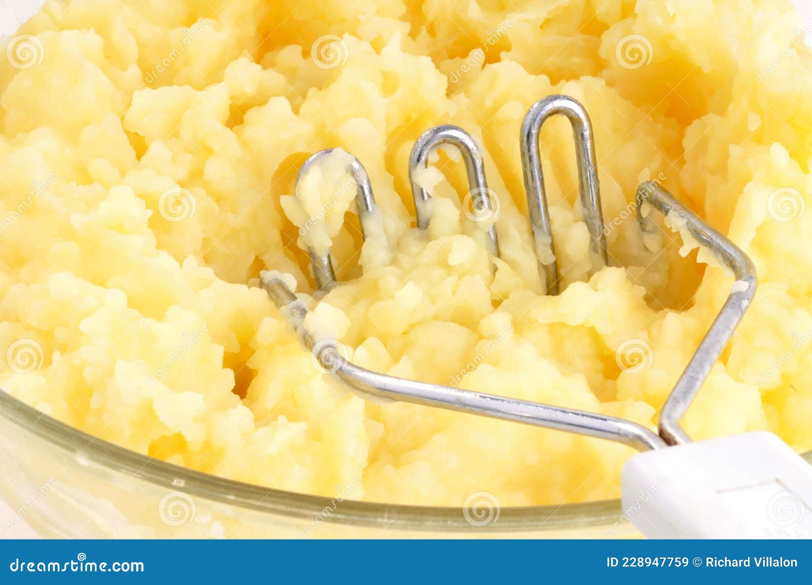 Bowl of Mashed Potatoes with a Potato Masher Closeup Stock Image
