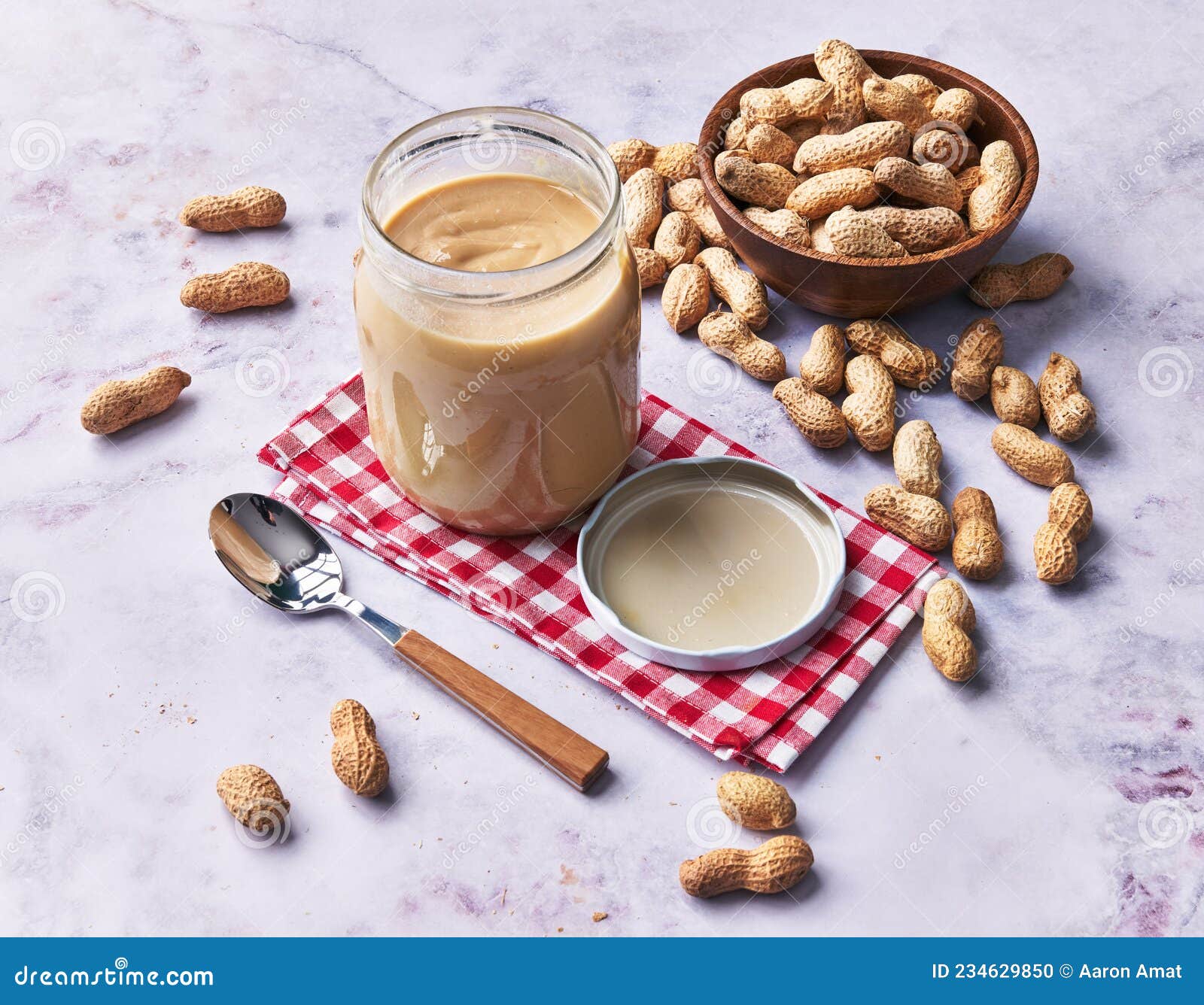 Bowl of Peanuts with Shell and Peanut Butter Cream on a Marble Surface