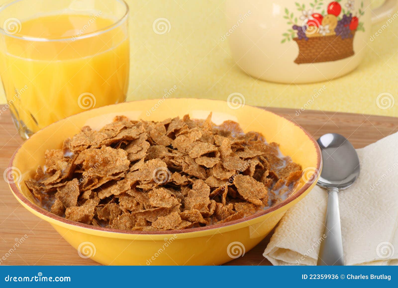 Bowl of Wheat Cereal. Bowl of wheat flake cereal and glass of orange juice