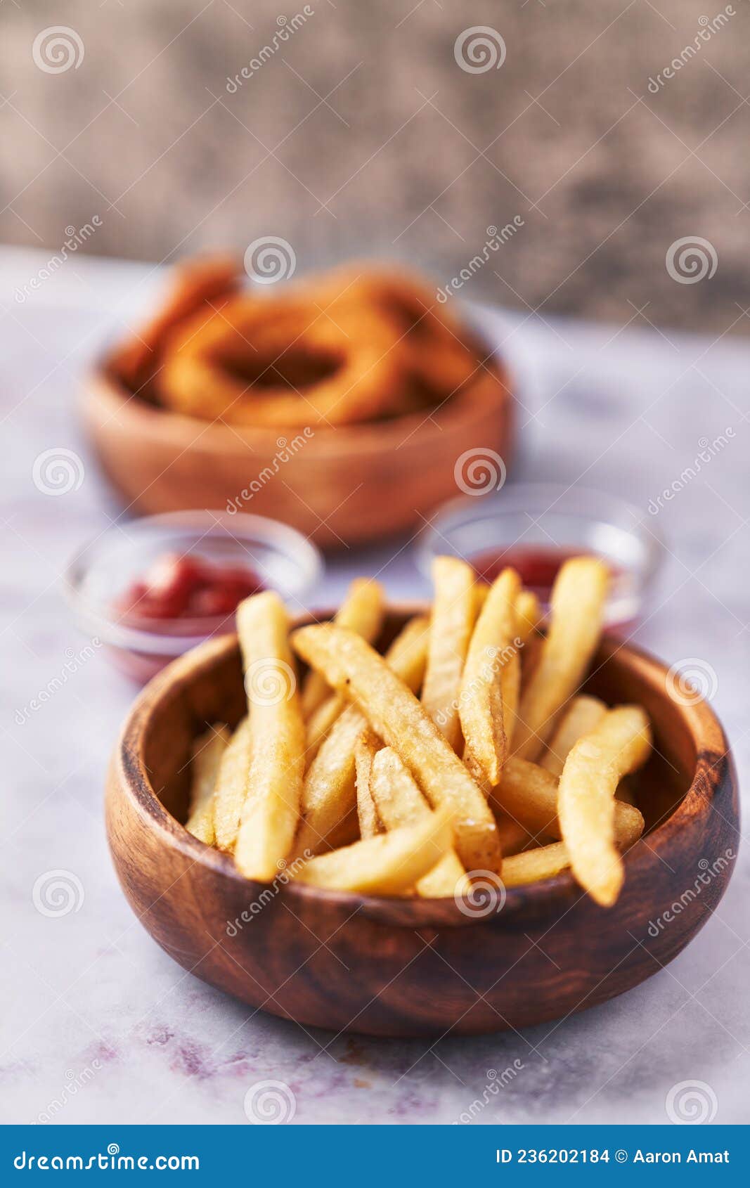 Bowls of Breaded Onion Rings and Potato Chips on a Marble Surface Stock