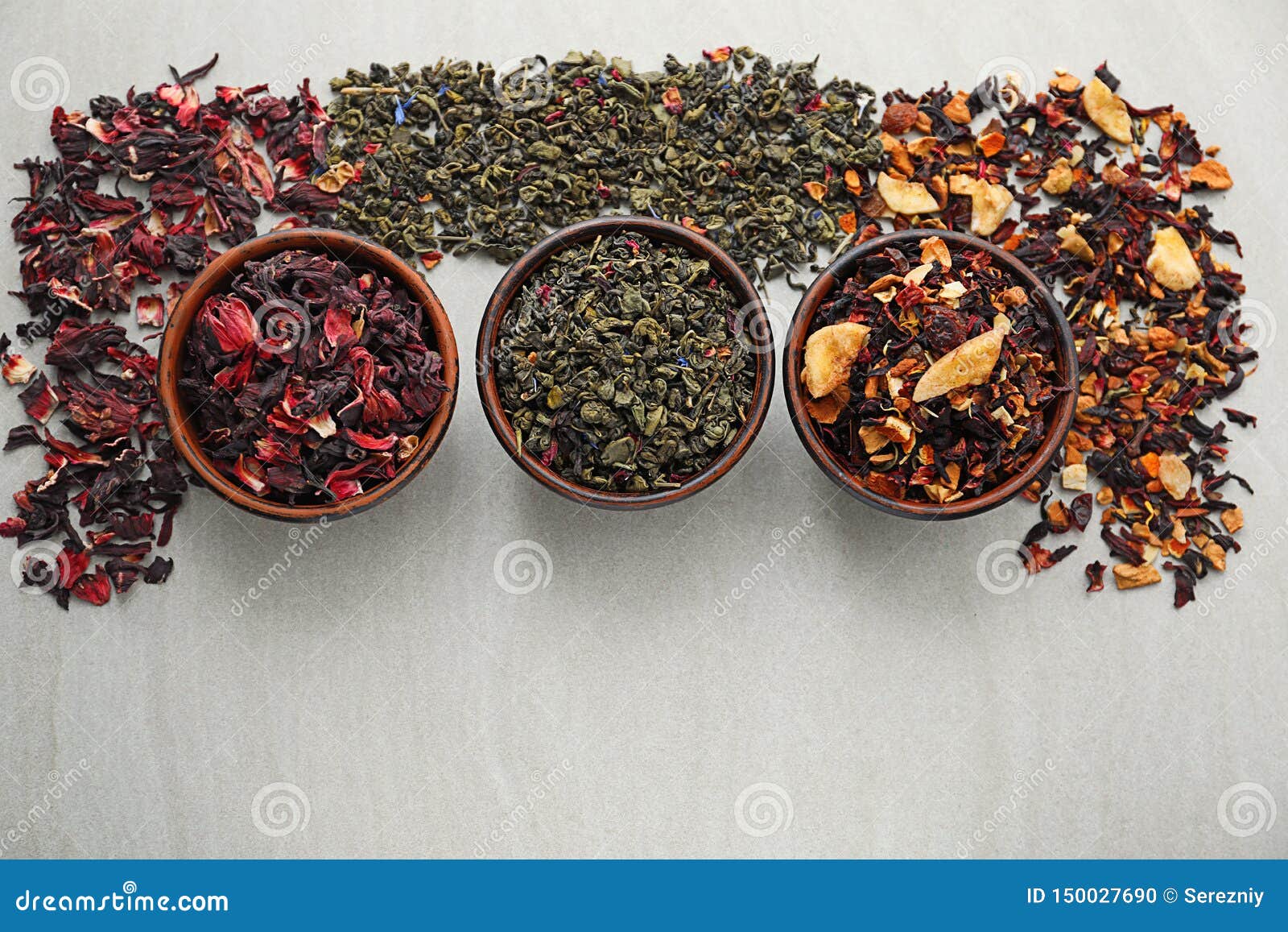 Bowls with Different Types of Dry Tea Leaves on Light Background Stock