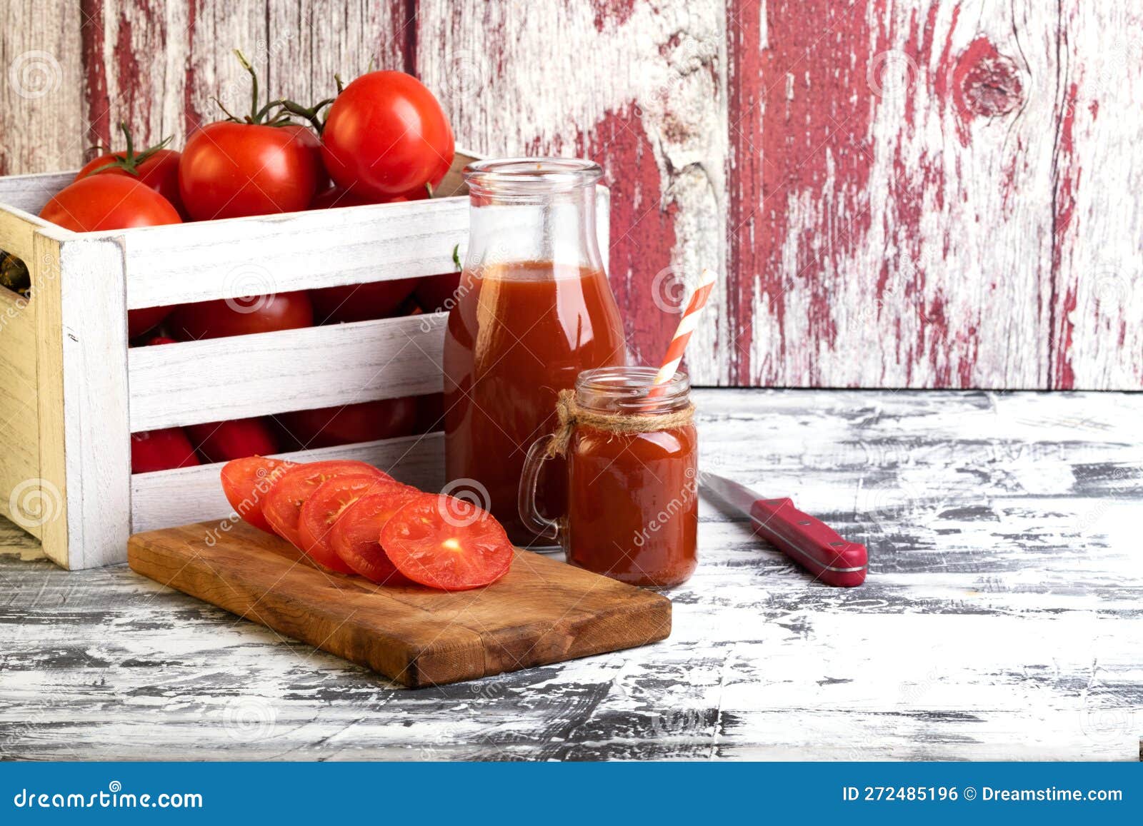 Box with Ripe Tomatoes and Tomato Juice in a Glass Bottle Stock Photo