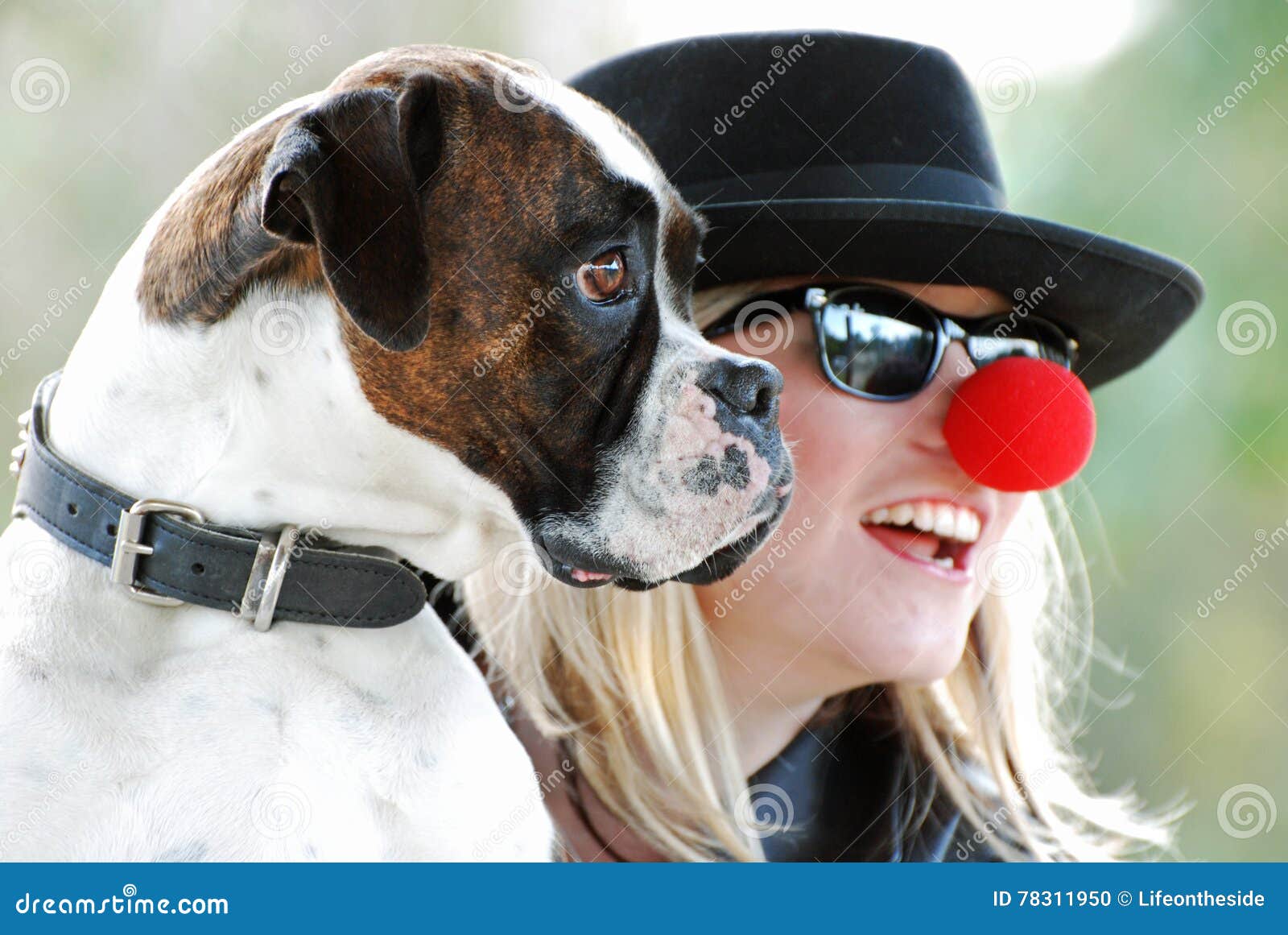 boxer dog posing for photograph with happy pretty young woman owner