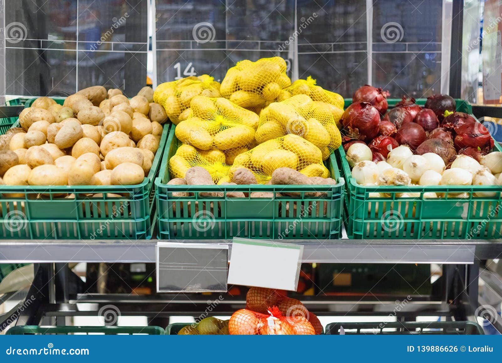 Boxes with Ripe Fresh Potatoes and Onions on Shelves Stock Photo