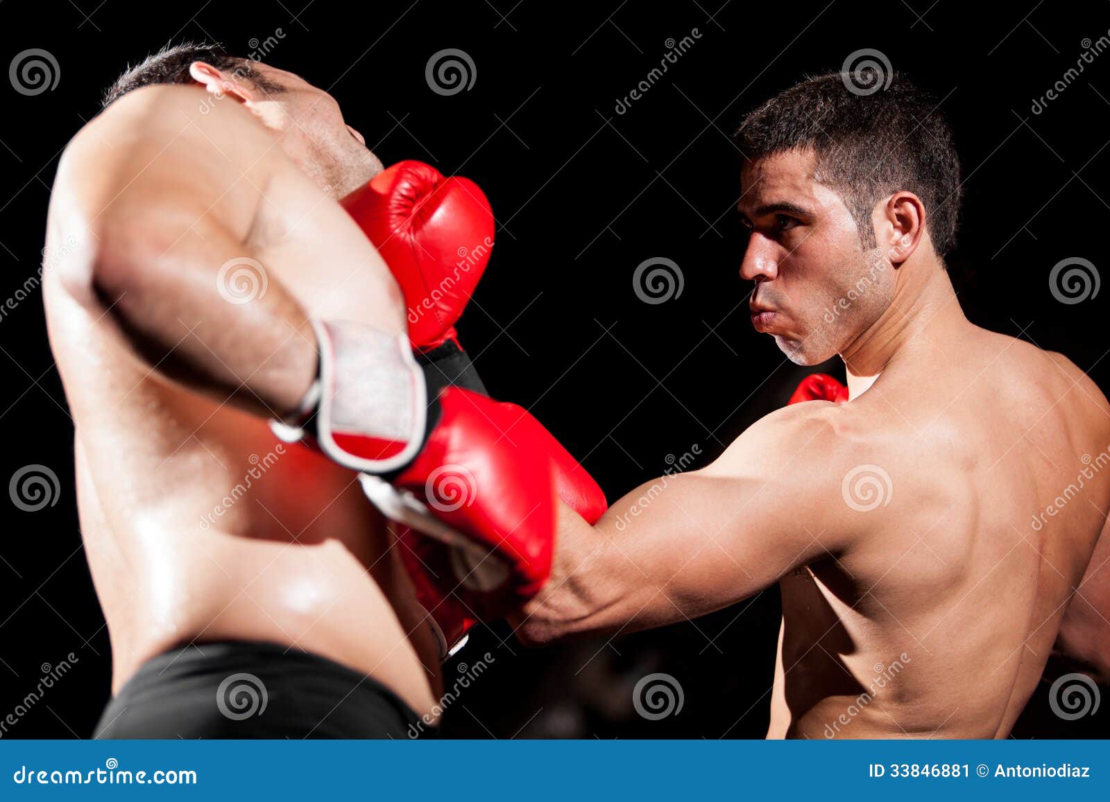 Boxing uppercut during a fight. Young Hispanic boxer throwing an uppercut and hitting his opponent during a box fight