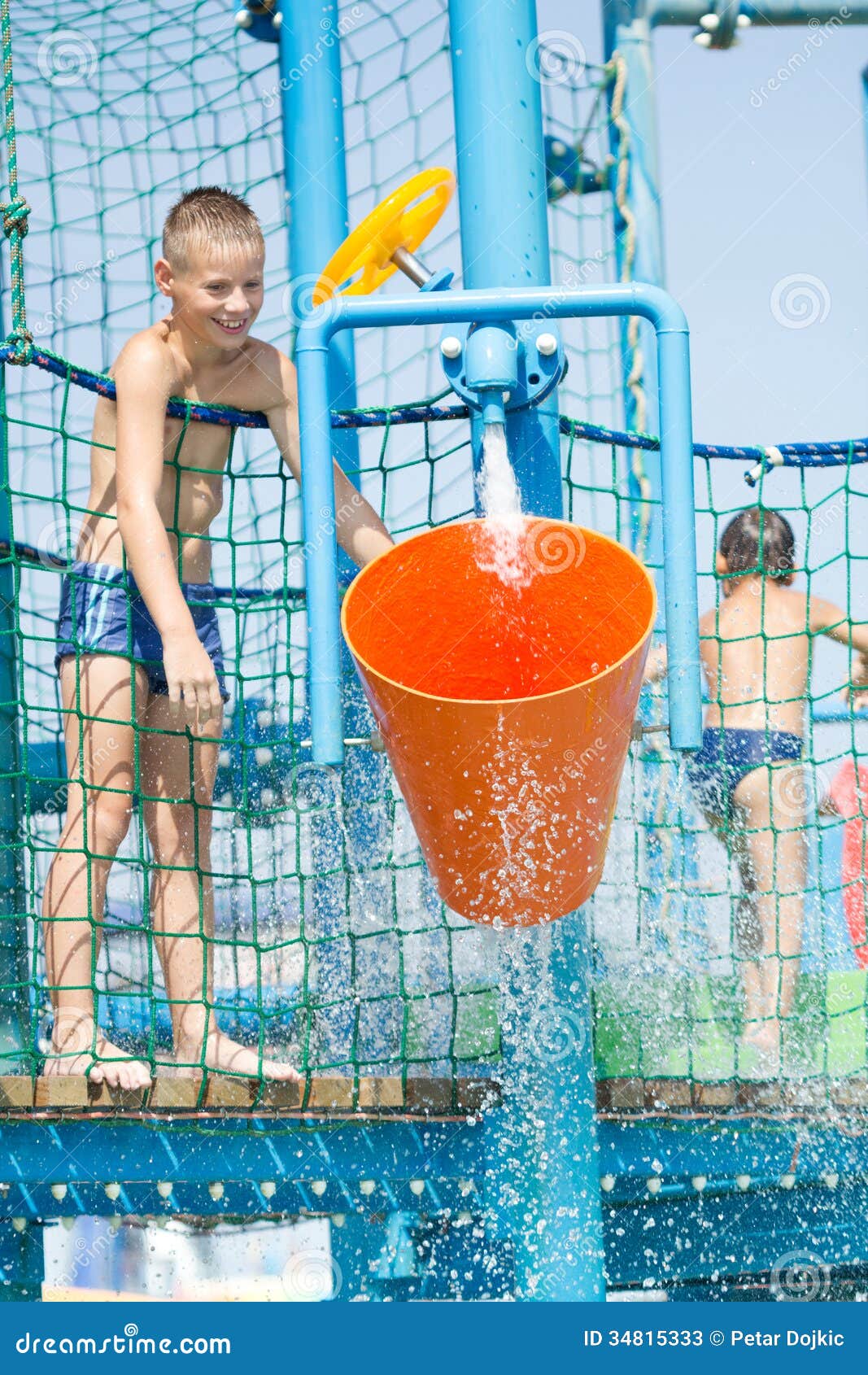 Two boys at water park in summer playing on slide near 