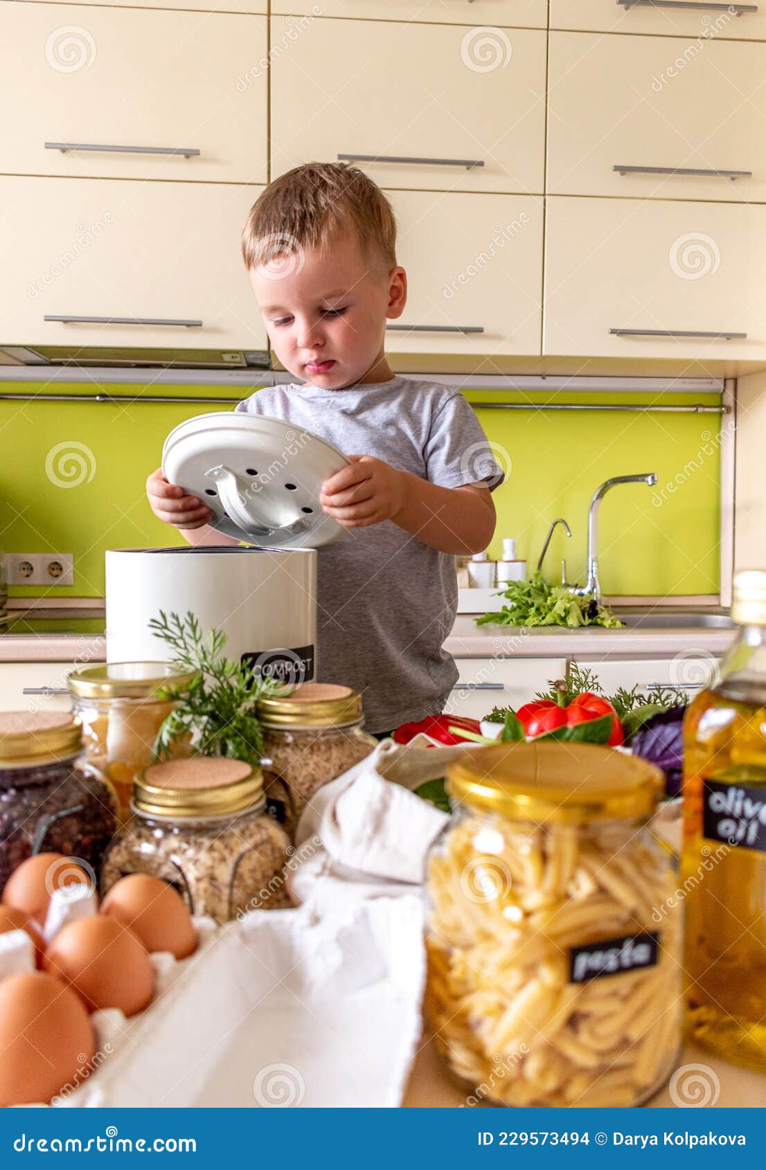 Boy Child Playing in the Kitchen with a Lid from the Compost Bin. Zero ...