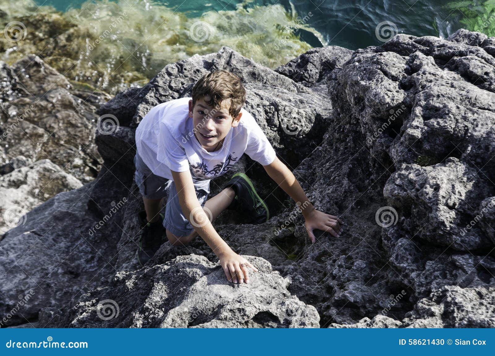 Boy climbing rocks stock photo. Image of outdoors, climbing 58621430