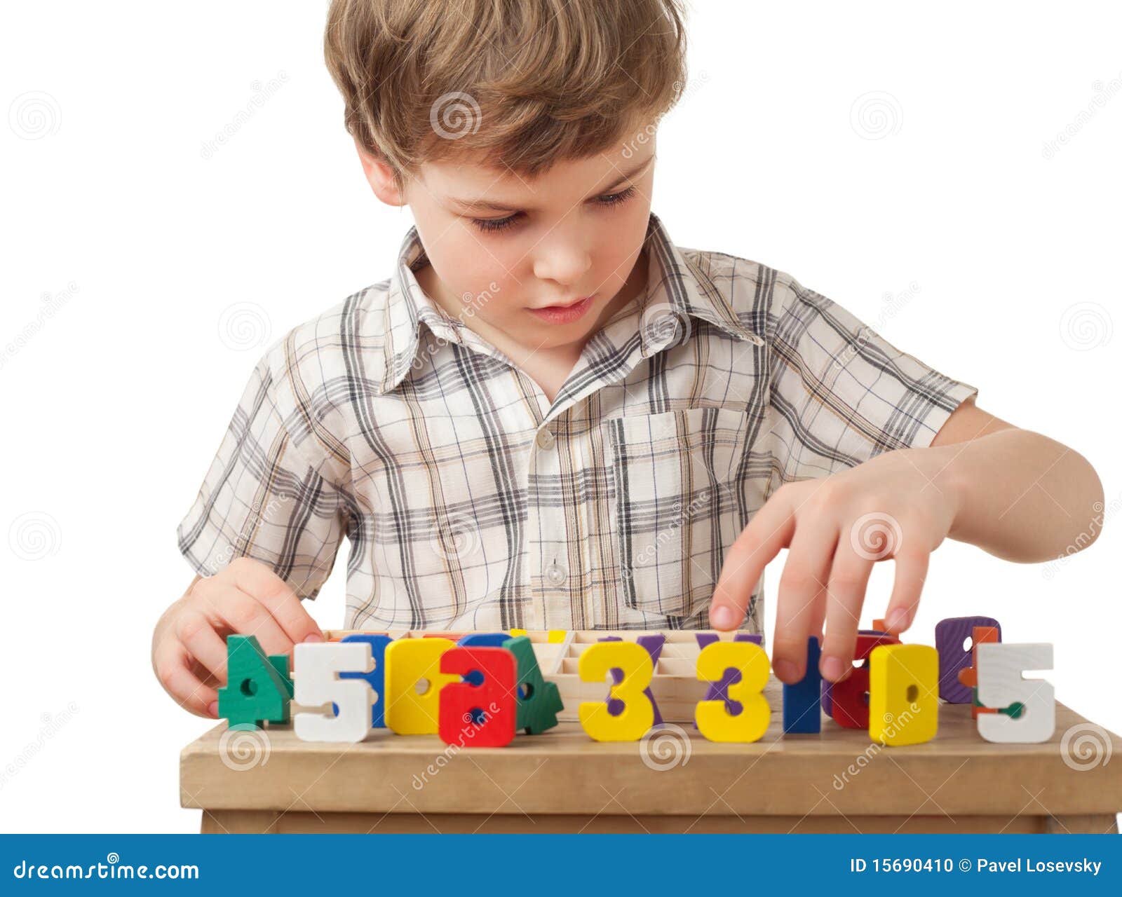 boy displays wooden figures in form of numerals