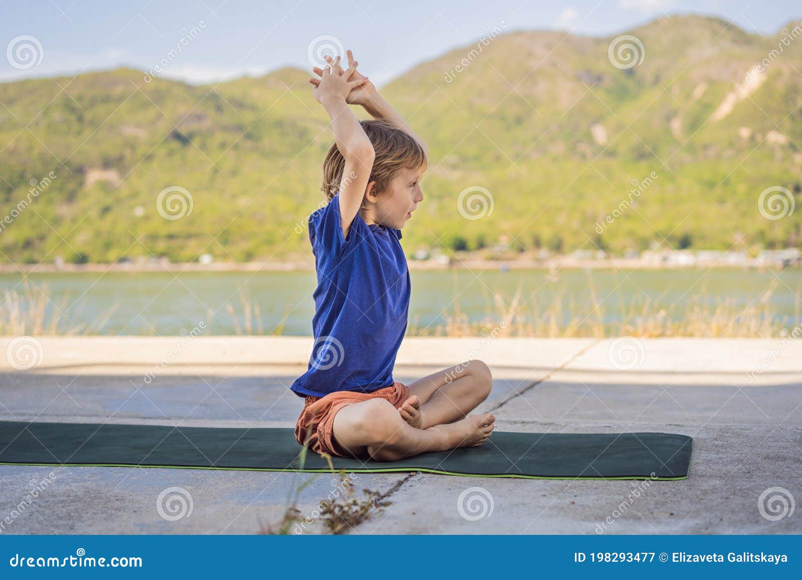 Boy Doing Yoga on a Yoga Mat Against a Background of Mountains Stock