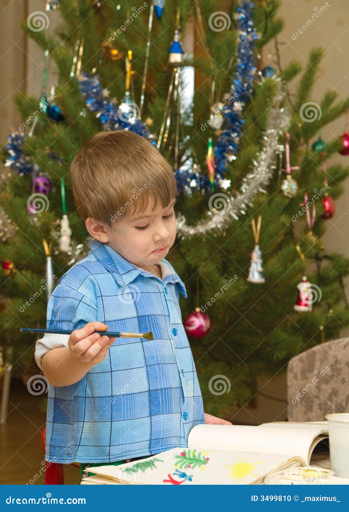 Boy drawing. Casual little boy indoor drawing. christmas tree background