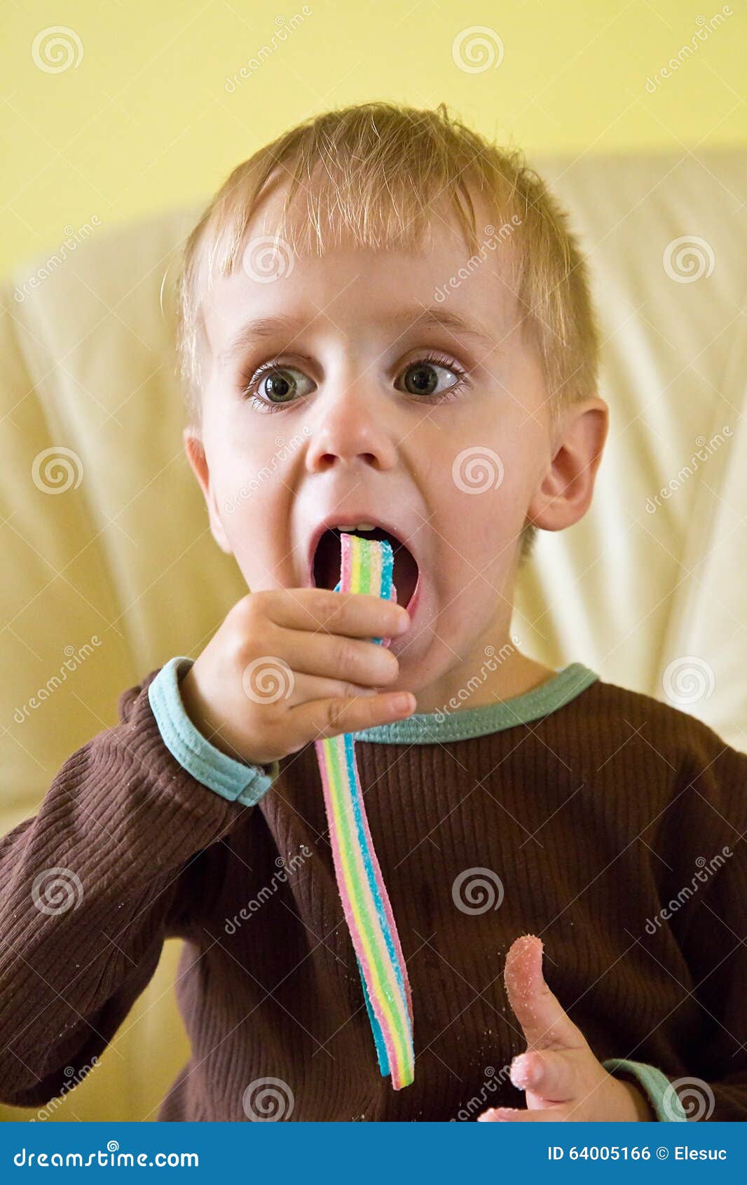 A boy eating jelly lollies stock photo. Image of antics 64005166