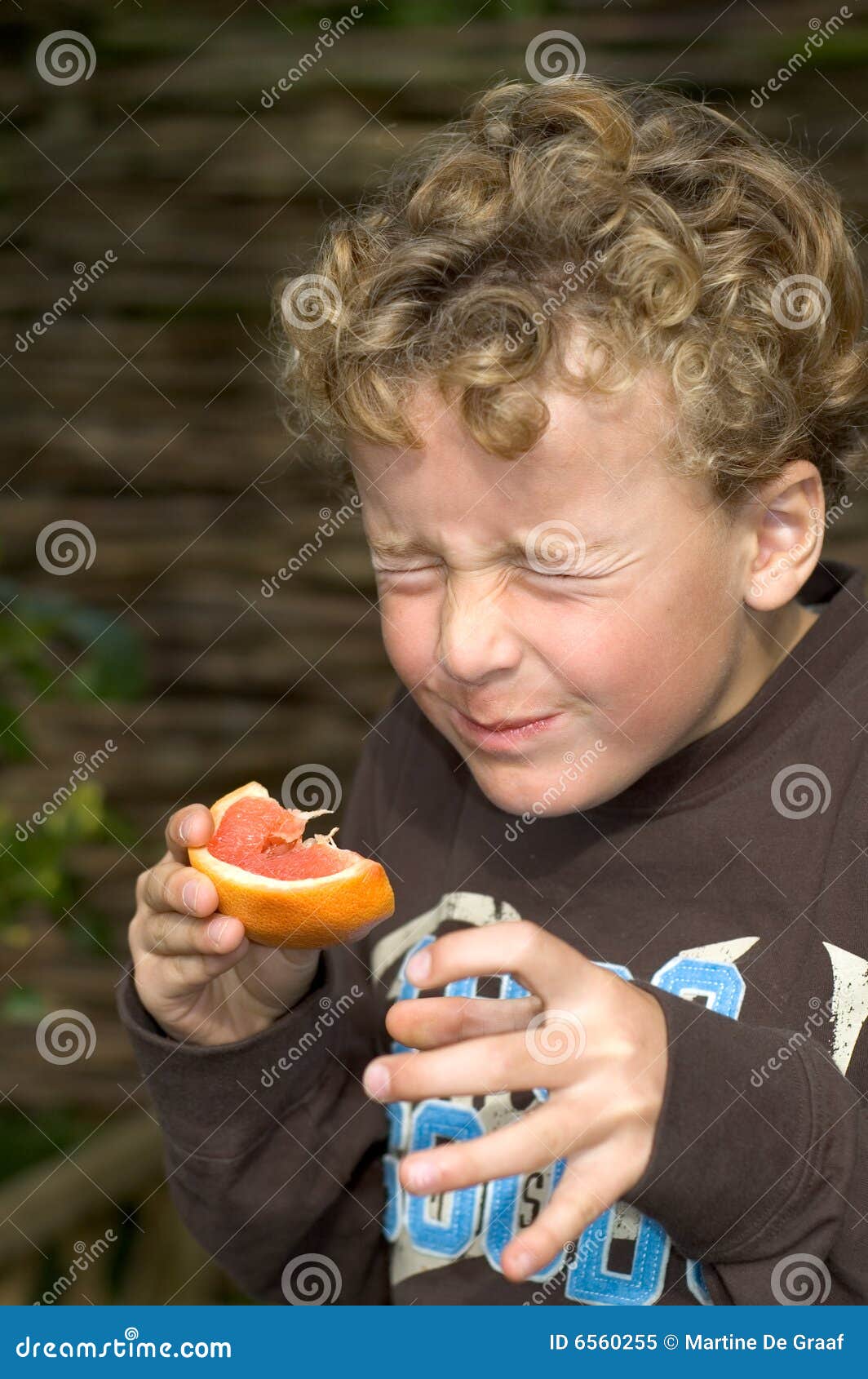 boy eating sour grapefruit